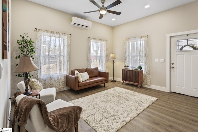 living room featuring dark hardwood / wood-style flooring, ceiling fan, a wealth of natural light, and a wall mounted AC