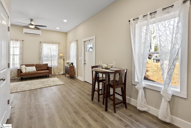 interior space with ceiling fan, hardwood / wood-style flooring, and an AC wall unit