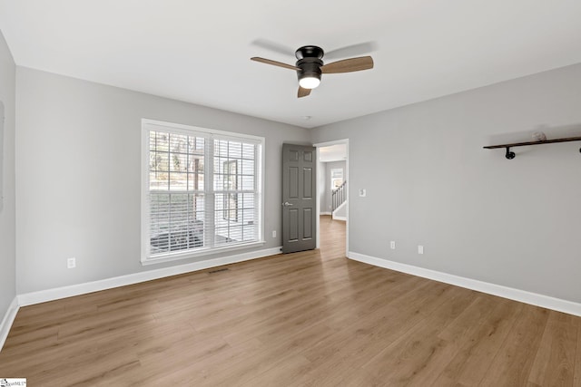 empty room with light hardwood / wood-style floors and ceiling fan