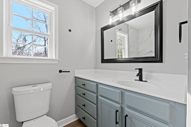 bathroom with plenty of natural light, vanity, and toilet