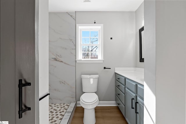 bathroom with toilet, a shower, vanity, and hardwood / wood-style floors