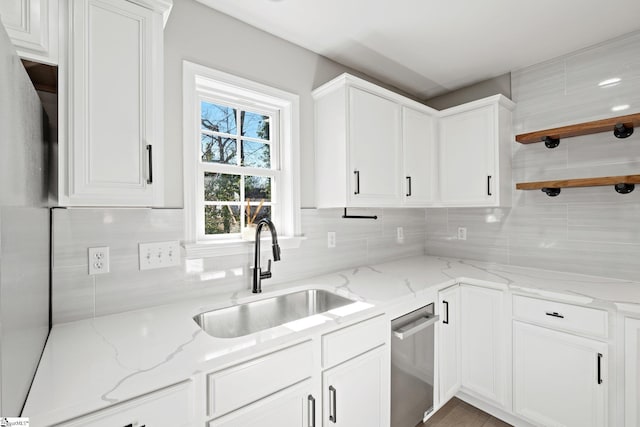 kitchen with sink, white cabinets, and light stone counters