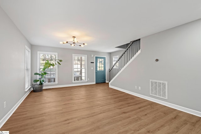 foyer with a notable chandelier and light hardwood / wood-style flooring