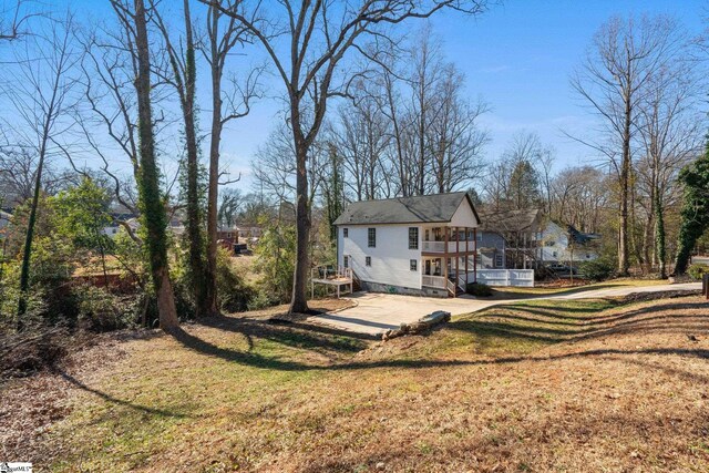 back of property with a balcony and a lawn