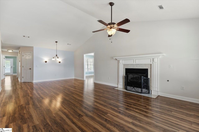 unfurnished living room featuring a high end fireplace, ceiling fan, a healthy amount of sunlight, and dark hardwood / wood-style floors