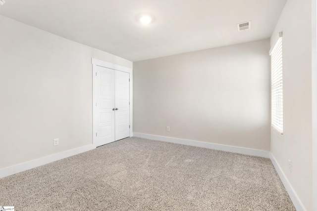 unfurnished bedroom featuring carpet floors and a closet