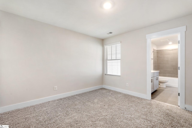 unfurnished bedroom with ensuite bath and light carpet