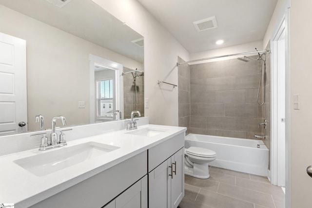 full bathroom with toilet, tiled shower / bath combo, tile patterned floors, and vanity