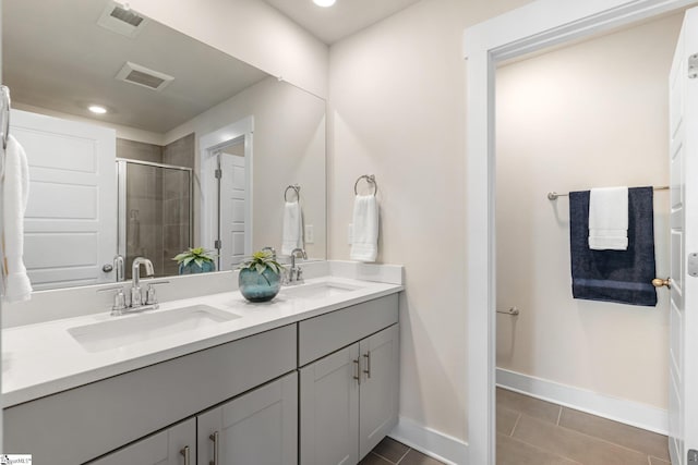 bathroom with a shower with door, tile patterned floors, and vanity