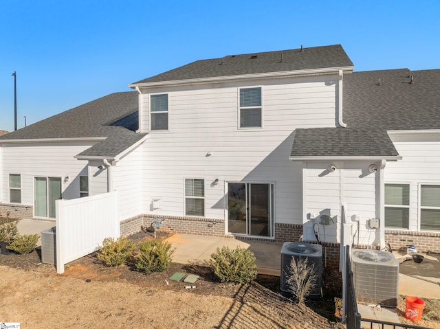 back of property with central AC and a patio