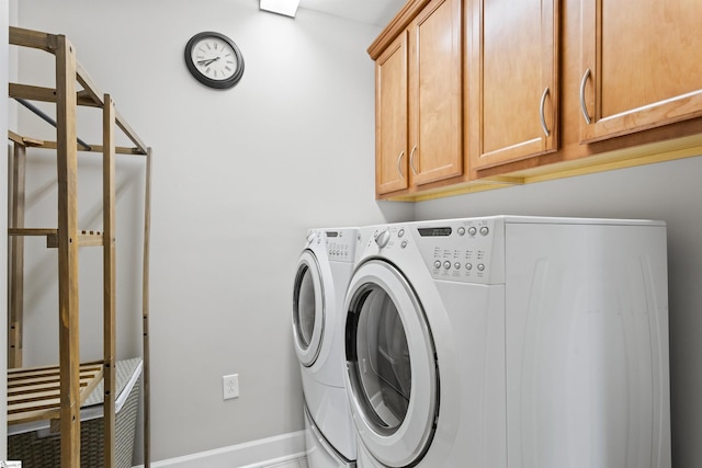 laundry room with washer and clothes dryer and cabinets