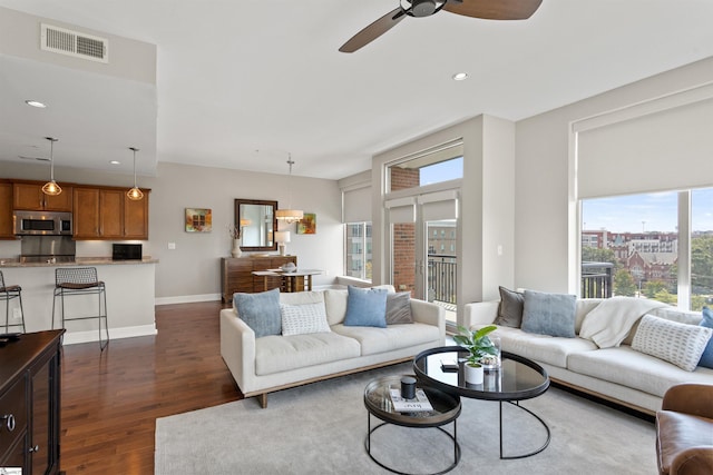 living room featuring ceiling fan and dark hardwood / wood-style floors