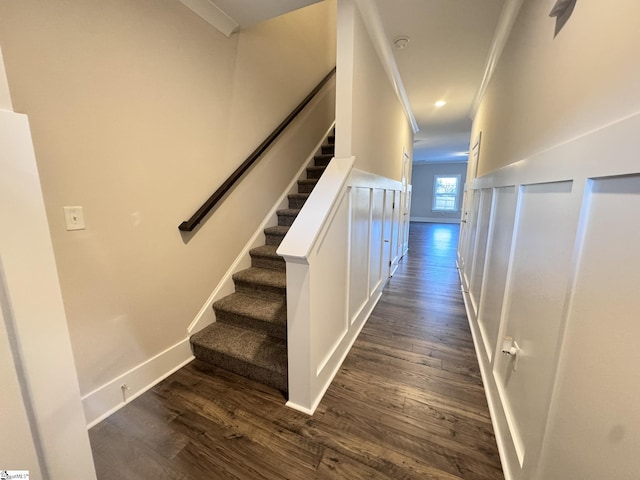 stairway with wood-type flooring and ornamental molding