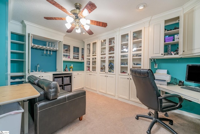 carpeted home office featuring wine cooler, crown molding, ceiling fan, a textured ceiling, and sink