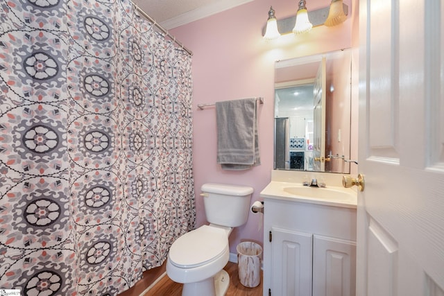 bathroom featuring a textured ceiling, ornamental molding, toilet, wood-type flooring, and vanity