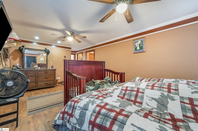 bedroom with wood-type flooring, a textured ceiling, ceiling fan, and ornamental molding