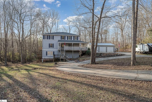 view of front facade featuring covered porch, a garage, and an outdoor structure