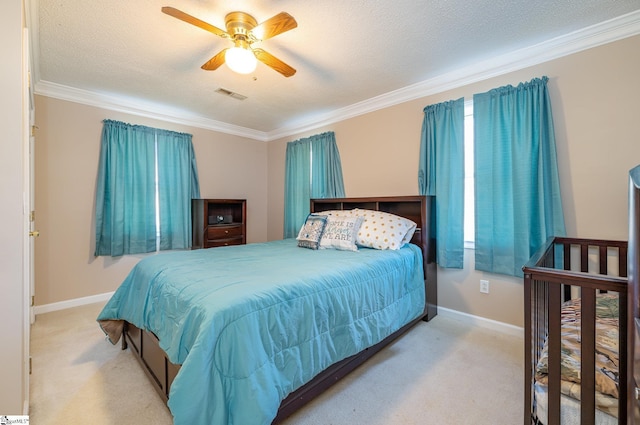 carpeted bedroom with a textured ceiling, ceiling fan, and crown molding