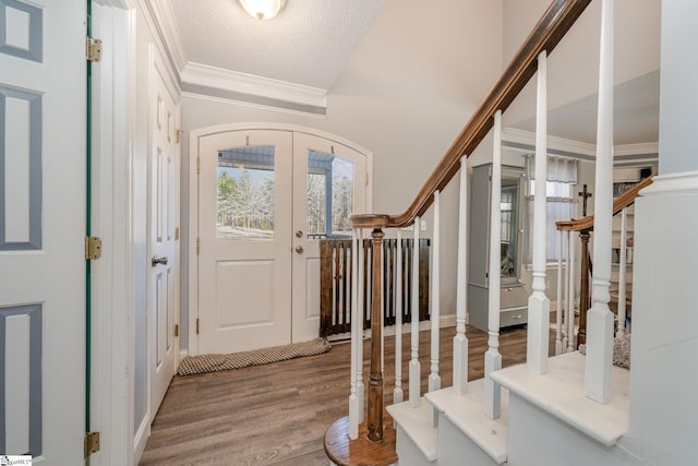 foyer entrance with hardwood / wood-style flooring, a textured ceiling, french doors, and a healthy amount of sunlight