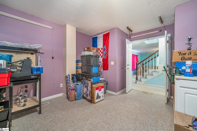 game room featuring a textured ceiling and light carpet