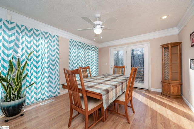 dining space featuring a textured ceiling, ceiling fan, light hardwood / wood-style flooring, and crown molding