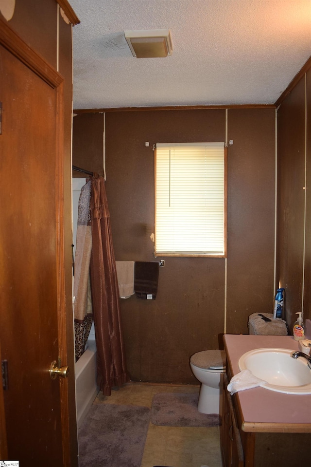 full bathroom with toilet, a textured ceiling, shower / bath combo with shower curtain, and vanity