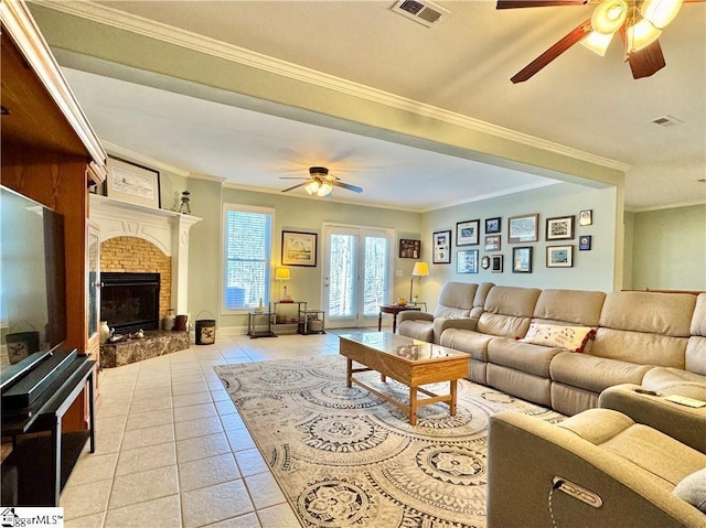 living room with ceiling fan, crown molding, a fireplace, and light tile patterned floors