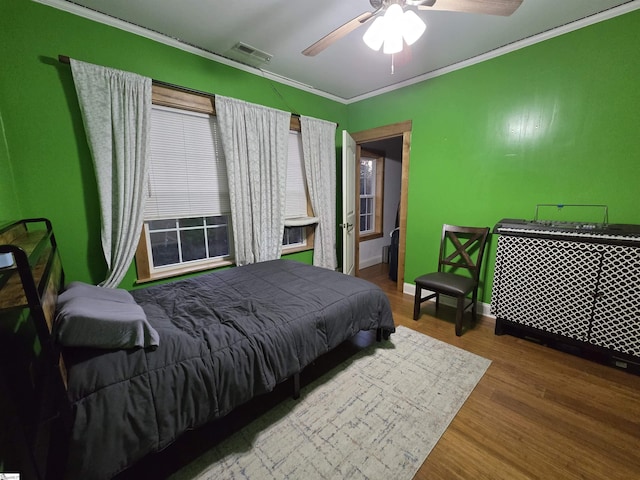 bedroom featuring ornamental molding, ceiling fan, and hardwood / wood-style floors