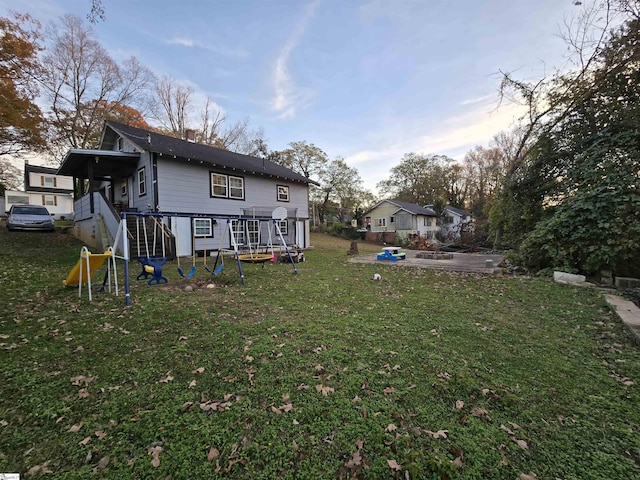 back of property with a lawn and a playground