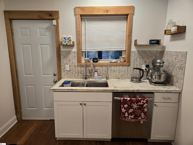 kitchen featuring dark hardwood / wood-style floors, sink, white cabinetry, stainless steel dishwasher, and backsplash