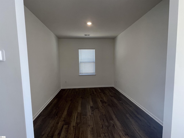 unfurnished room with dark wood-type flooring