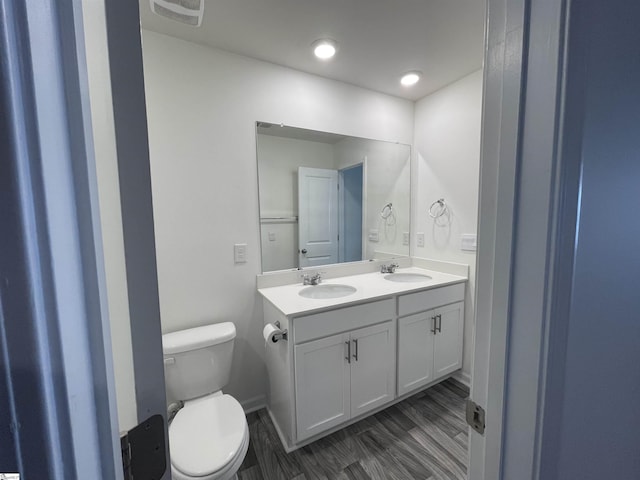 bathroom featuring toilet, vanity, and hardwood / wood-style flooring