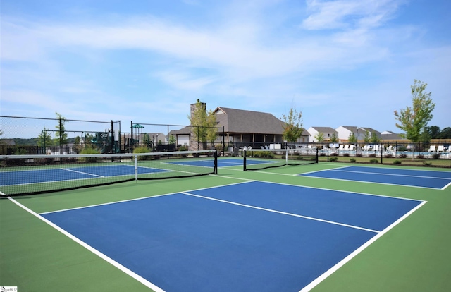 view of tennis court with basketball hoop