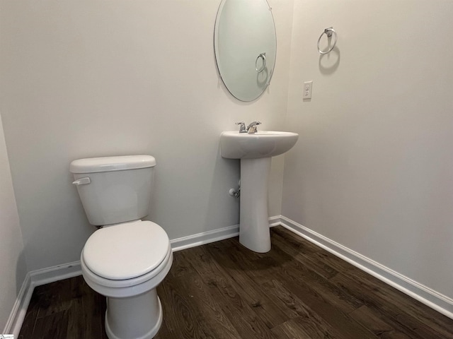 bathroom featuring toilet, sink, and hardwood / wood-style floors