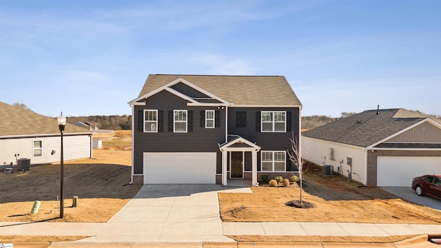 view of front of property featuring a garage, concrete driveway, and central air condition unit