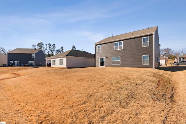 rear view of property featuring a lawn