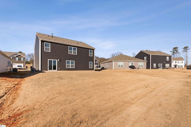 rear view of property with a lawn and central AC