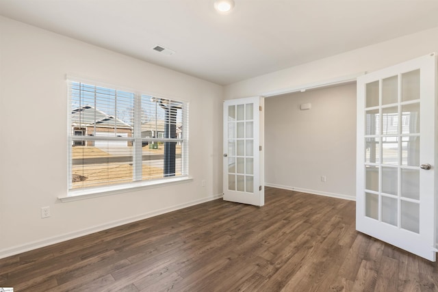 empty room featuring dark hardwood / wood-style flooring and french doors