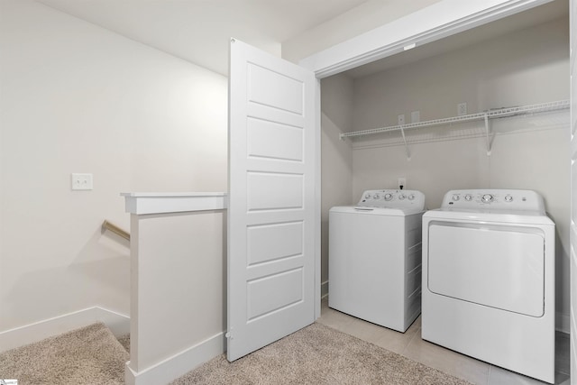 laundry area with washer and dryer and light tile patterned floors