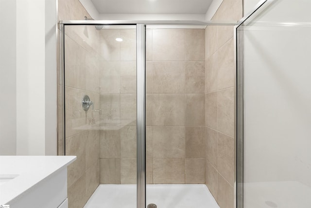 bathroom featuring a shower with door and vanity