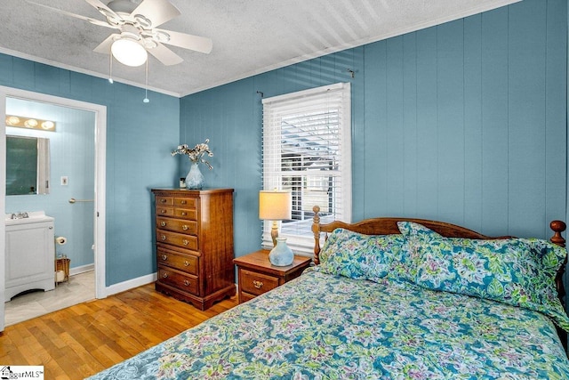 bedroom featuring ceiling fan, washer / dryer, connected bathroom, and crown molding