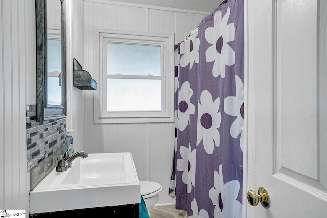 bathroom with toilet, decorative backsplash, and sink