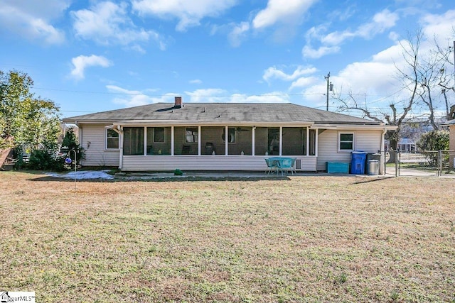 rear view of house with a lawn and a sunroom