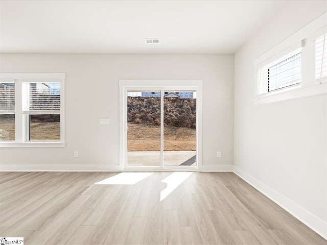 unfurnished room featuring light hardwood / wood-style floors and a wealth of natural light