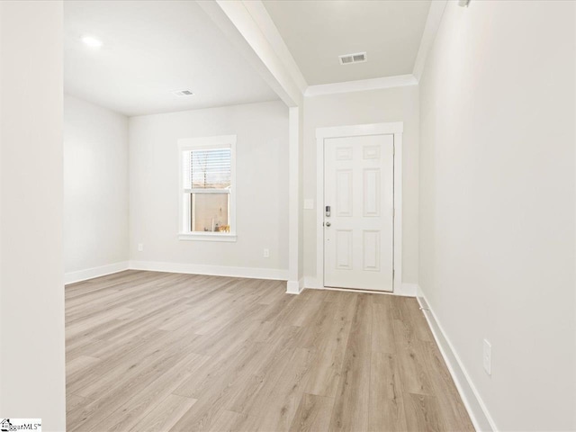 foyer entrance featuring crown molding and light hardwood / wood-style flooring