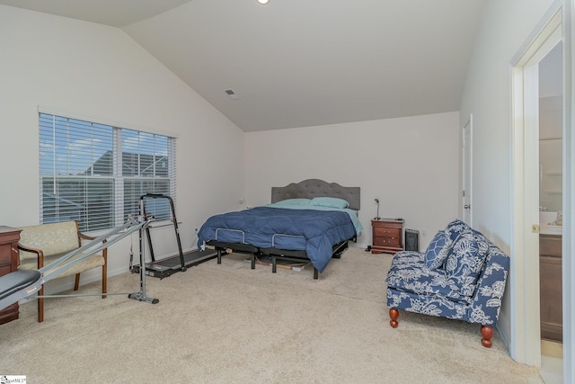 bedroom featuring ensuite bathroom, vaulted ceiling, and carpet flooring