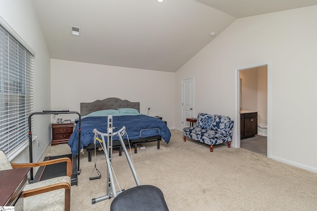 carpeted bedroom with lofted ceiling and ensuite bath