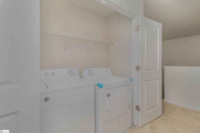 clothes washing area featuring washing machine and clothes dryer and light carpet