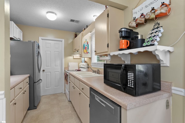 kitchen featuring a textured ceiling, dishwashing machine, white range with electric stovetop, stainless steel refrigerator, and white cabinets