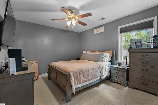 bedroom with ceiling fan and a textured ceiling